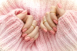 Nail Polish. Art Manicure. Modern style pink Nail Polish.Stylish pastel Color pink Nails holding wool material sleeve blouse . Classic wedding bride nails design