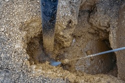 A plumber using hydro excavator to repair a leaking main water line. An excavating crew using a hydro vac to gain access to a leaking main water line. 