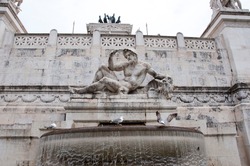 Sculptural detail of Vittoriano fountain with carved marble male statue.