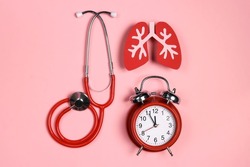 Prevention of pulmonary disease. Lung symbol, stethoscope and alarm clock on a pink background. Healthcare and medicine concept. 