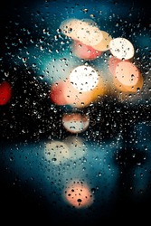 Window with raindrops and bokeh