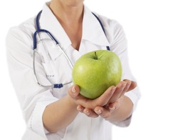 Doctor (woman) holding green apple with copy space on blue