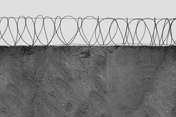 Barbed wire over a concrete wall. The concept of deprivation of liberty or restriction of territory in industrial production. no people. Copy space. front view.