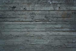 large grey concrete wall texture as background on which you can see the imprint of a few formwork boards