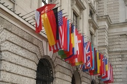 Flags of many different countries flying against stone building. Image has copy space. Hofburg, Vienna, Austria.