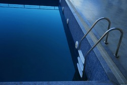 blue Swimming Pool with iron Stairs and dirty water inside.   swimming pool ladder.  metal Steps. 