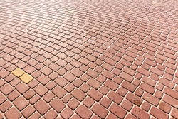 Top view on red paving stone road. Old pavement of granite texture. Street cobblestone sidewalk. Abstract background for design.