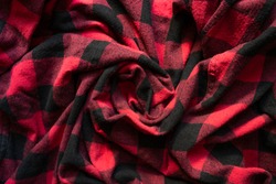 Wrinkled black and red cell clothes background. Fabric with black red cages pattern. Plaid material. Crumpled Cloth Blank Background