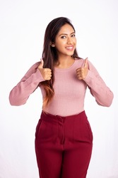 Pretty Indian young business woman showing thumbs up on white.