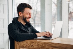 Stylish male freelancer working on new startup project making internet researchers analyzing data using laptop computer