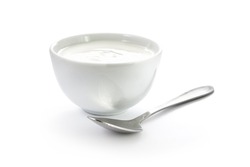 Hand-made yogurt in a bowl with spoon isolated on white background