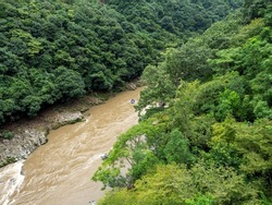 Top view of green forest and muddy water brook with small rafting boat.enjoy outdoor life concept.