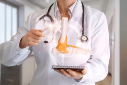 Doctor showing foot bone disease on blurred background hospital.