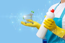 Cleaning lady shows the shopping cart and cleaning products on a blue background.