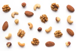 Isolated nuts pattern backdrop. Walnut, cashew, almond and hazelnut  on white background. Top view. 