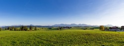 Idyllic farmland landscape in the Alps, fresh green agricultural land with mountain in background, Allgäu, Bavaria, Germany
