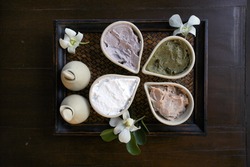 exotic herbs and body scrub ingredient set in a wooden plate
