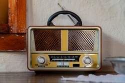Retro broadcast radio receiver on wooden table