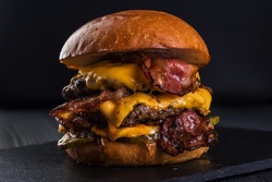 Burger. Double cutlet, double cheddar cheese, bacon, deep-fried onions, pickles, sauce and craft bun.
