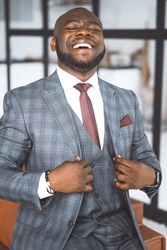 Concept Of Successful Business, Rich Life. African-American Tycoon Shows Contentment And Superiority. In Stylish Expensive Suit, Man Laughs. High quality photo