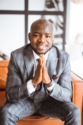 Happy Laughing Rich African American Businessman. Successful Tycoon Folded Hands Gesture In Stylish Expensive Suit. Concept Of Rich Life, Successful. High Quality Photo 