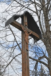 An old wooden cross with a metal Christ in a cemetery in Slovakia.