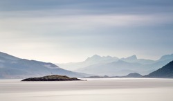 Coast of  Norway sea in clouds of haze. Beacon on a rock. Cloudy Nordic day on Lofoten islands