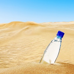 bottle of mineral water on the sand in the desert