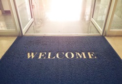 Welcome blue mat in front of door, shop