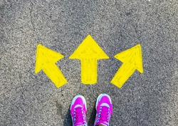 Female pink sport shoe with yellow drawn direction  arrow as guidance, top view. Young street lifestyle, which way your choice