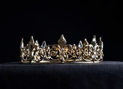 close up portrait of royal golden crown, isolated on dark black background.