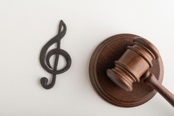 Treble clef symbol and judges hammer. Violation of music copyright. Digital piracy