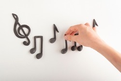 Treble clef and musical note in child hands on white background. Key of G. Music symbol
