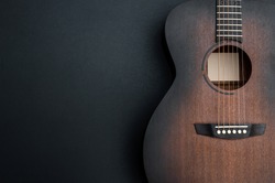 Acoustic guitar on black background. Space for text.