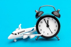 Airplane toy with alarm clock on blue.  Time to flight.