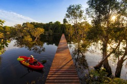 Travel Kayaking, Women Paddling Transparent Canoe Kayak in peat swamp forest wetlands in morning sunrise, Rayong botanic garden, A Wetland Sanctuary of Eastern Thailand, Rayong Province, Thailand