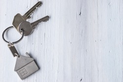 Real estate concept - Key ring and keys on white wooden background - Copy space
