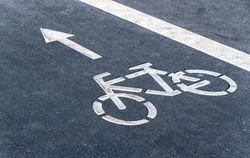 Bicycle symbol on a bike lane with directional arrow of movement. Bicycle lane for bike rider