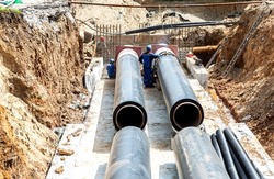 Replacement of heating pipes and modernization of the heating system. Construction works on large iron pipes at a depth of excavated trench. Carrying out construction and repair work in the city