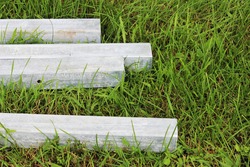 four concrete blocks lie on the grass. blanks for pillars