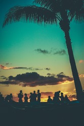 Young People At Retro Styled Hawaiian Sunset Beach Party