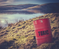 Conceptual Image Of A Toxic Waste Barrel Or Drum Near Water In The  Countryside