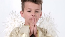 Baby boy praying he in the form of an angel with white wings in the studio on white.