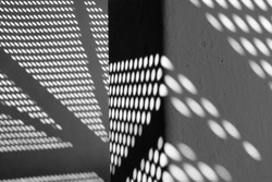 Black and white photography of modern architecture detail with shadows on the wall.
