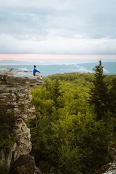 Woman sitting on a rock's edge at Bear Rocks Preserve in the Dolly Sods Wilderness, West Virginia