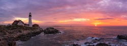 Panorama of Portland Head Lighthouse with the rising sun and colorful clouds