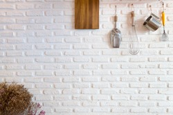 Some kitchenware hang on white brick wall : use for background