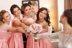 Wedding photography. Bride gives her wedding bouquet to the bridesmaids after wedding ceremony