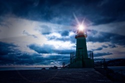 Lighthouse on the sea at night, cloudy sky