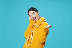 asian woman in yellow sweater scarf winter clothes blue background